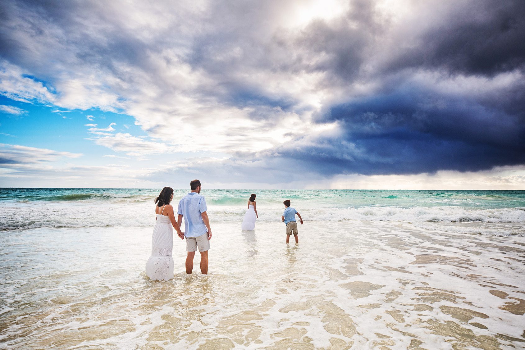 family walking into the ocean during a hawaii photo session